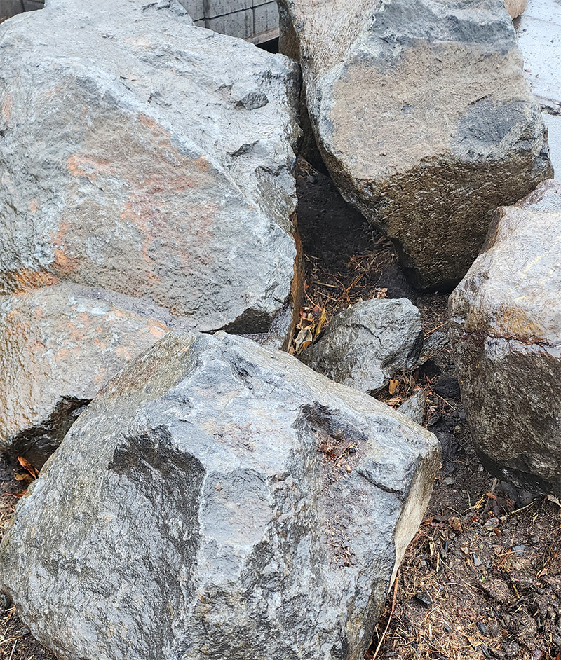 wet boulders sitting on dirt