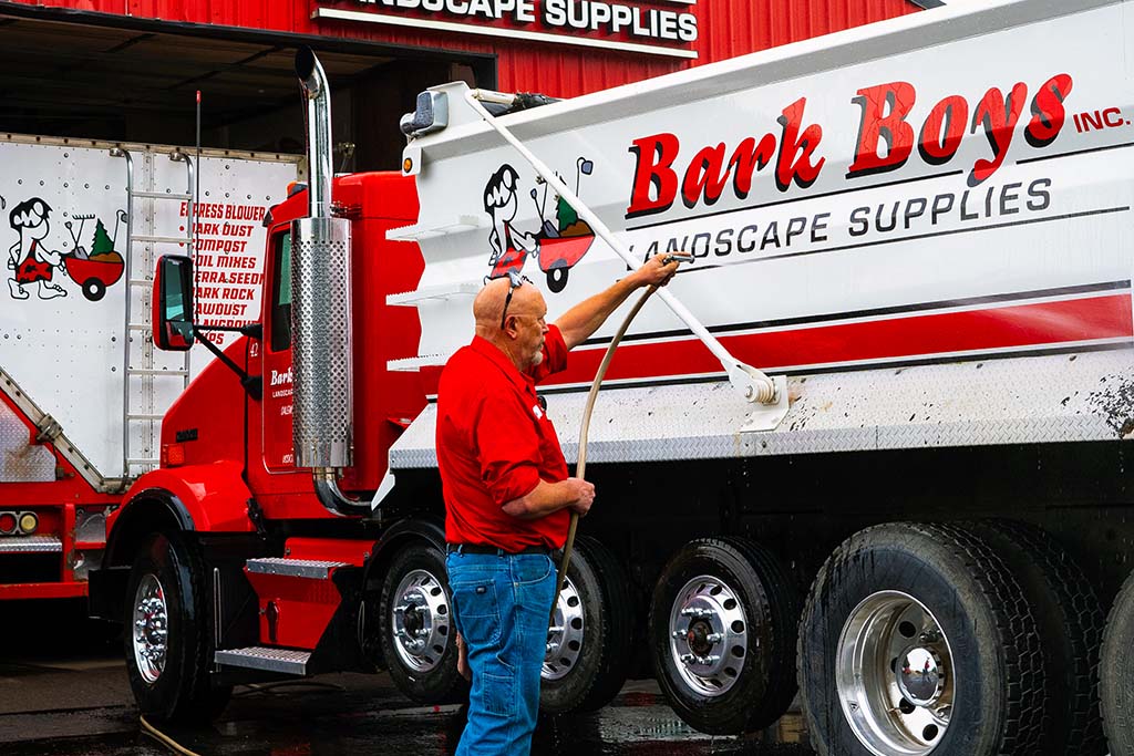 Grassy lawn with fresh bark dust, Bark Boys truck in the back