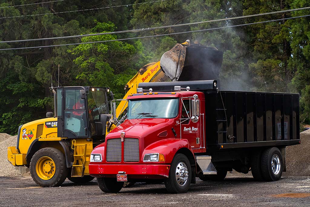 Bark Boys employee using express blower to spread bark dust quickly